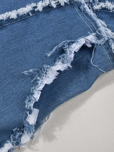 Gros plan sur le denim bleu montrant les bords à franges et la texture délavée