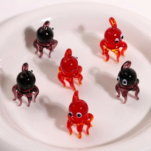 Detailed view of handmade glass octopus pendants in red and purple for jewelry making