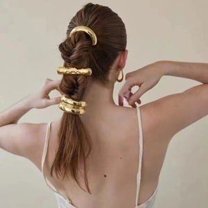 Minimalist gold stainless steel hair tie set shown on a model with elegant styling