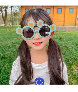 Close-up of cute mint green bear-ear sunglasses on a young girl for sun protection
