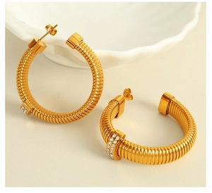Detailed shot of golden twisted hoop earrings with sparkling zircon micro-pave accents