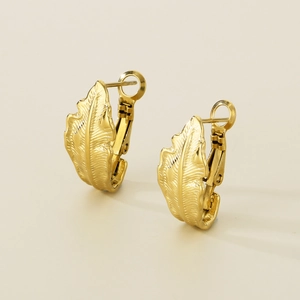 Close-up of minimalist leaf-shaped gold hoop earrings featuring fine realistic vein texture