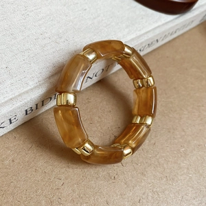 Detailed macro shot of an amber resin and gold bead elastic ring on a book side