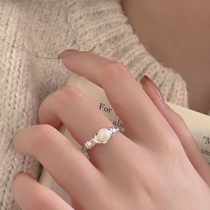 Minimalist 925 sterling silver pearl ring with a woven rope texture band on a finger