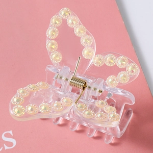 Detailed close-up of a butterfly hair claw featuring yellow rhinestones and metal spring