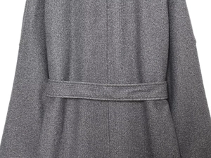Detailed close-up of gray wool coat back stitching and textured belt buckle finish