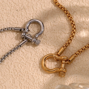 Macro shot of gold and silver box chains with industrial U-shaped horseshoe clasps