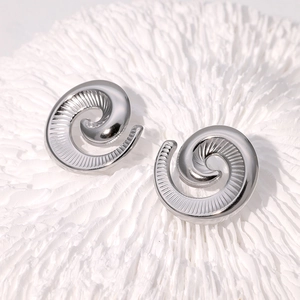 Makroaufnahme silberner Ohrstecker mit poliertem Spiralmuster und Metalltextur