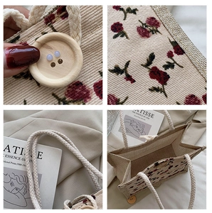 Detail view of beige corduroy tote with red floral pattern and wooden button closure