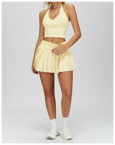 Detail view of the yellow pleated tennis skirt with built-in safety shorts and elastic fabric