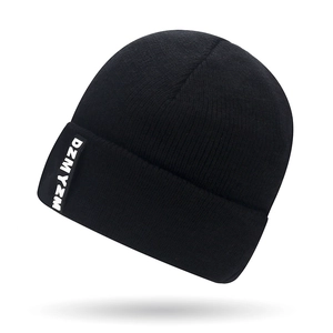 Black knitted beanie hat with letter patch and thick ribbed texture for winter warmth