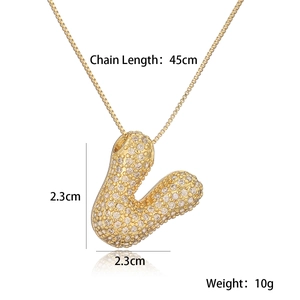 Detail view of gold letter V necklace pendant with clear gems and size specifications