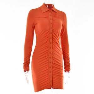 Detail of orange button-down mini dress featuring polo collar and ruched side textures