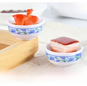 Macro detail of miniature roasted duck and braised pork in traditional porcelain bowls