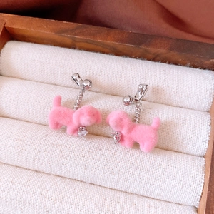Detailed macro view of pink flocked puppy earrings with a heart-shaped zircon drop