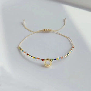 Details des verstellbaren böhmischen Miyuki-Perlenarmbands mit goldenem Anhänger und Kordel