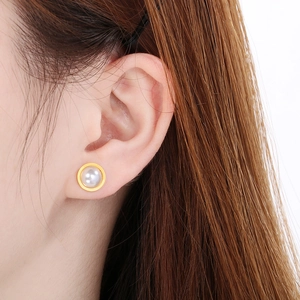 Gros plan d'une boucle d'oreille en perle blanche avec bordure dorée de style français