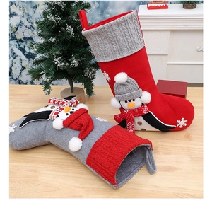 Christmas stockings featuring plush 3D penguin and snowman on festive wooden table background