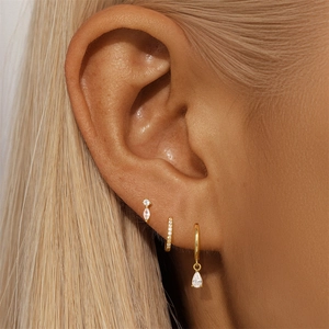 Close-up of gold S925 silver opal star earrings and CZ hoops set on a model ear