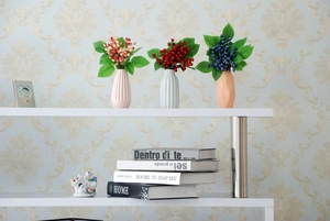 Close-up of artificial berries in ceramic vases on a shelf for home decor