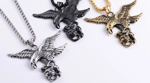 Macro detail of punk eagle claw and skull pendant in silver, gold, and black finish