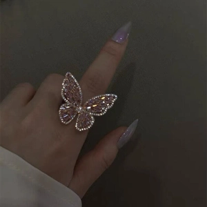 Macro detail of the butterfly open ring with pink zircon stones worn on the finger