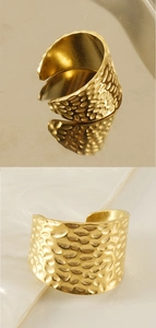 Detailed view of wide golden hammered texture open ring with metallic reflection