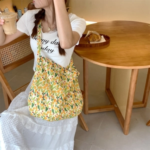 Detailed view of yellow tulip floral canvas tote bag during casual outdoor use