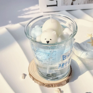 Polar bear jelly candle in a glass jar on a wooden coaster for home decor