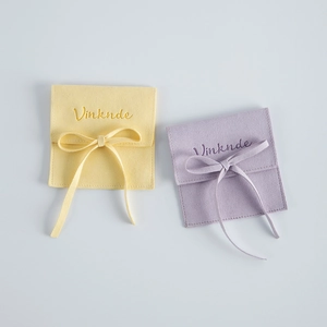 Microfiber velvet jewelry pouches in yellow and purple with elegant ribbon bows