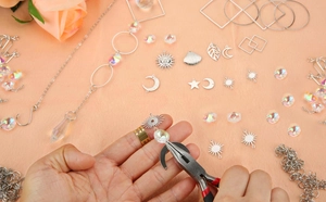 DIY kit showing a person assembling sun moon charms and crystal beads with pliers