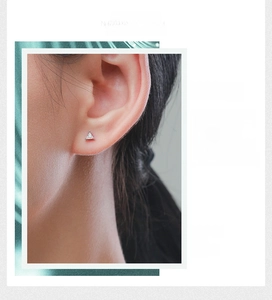 Detail of s925 silver triangle stud earring with sparkling cubic zirconia on model