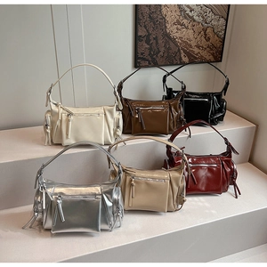 Détail de divers sacs à bandoulière pour femmes avec fermetures éclair et finition brillante