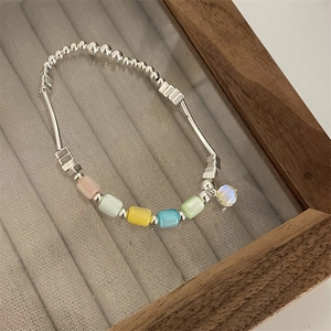 Detailed shot of beaded bracelet with silver tubes and colorful candy-toned square beads
