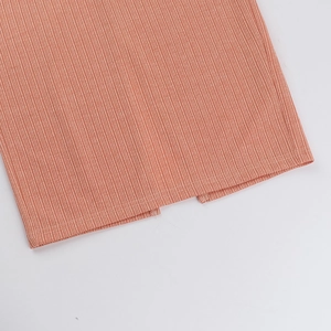 Dettaglio dell'orlo in maglia a coste rosso mattone con un piccolo spacco preciso
