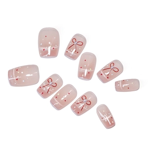 Faux ongles œil de chat rose avec nœuds, perles et pois colorés sur fond blanc
