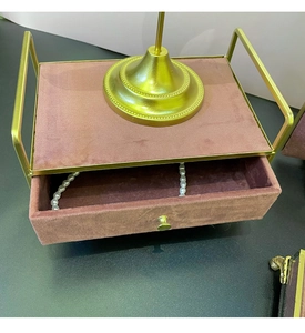 Detailed view of luxury gold metal frame jewelry organizer with soft purple velvet drawer