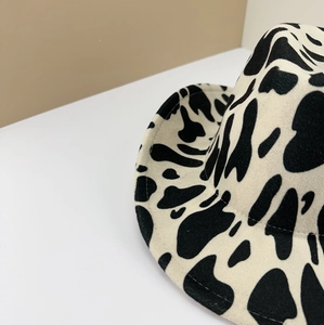 Detailed view of the cow print pattern and fine stitching on a felt cowboy hat
