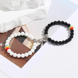 Detail of magnetic heart-shaped clasp on rainbow beaded couple bracelets set