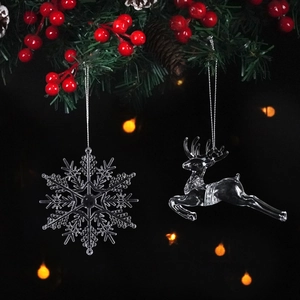 Transparent crystal Christmas ornaments with snowflake and reindeer on pine branches