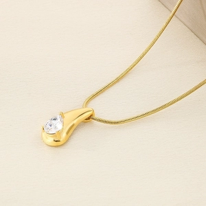 Close-up of 18K gold plated teardrop pendant with sparkling crystal on snake chain
