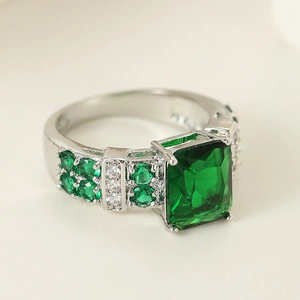 Detailed view of silver emerald-cut green stone ring with side zircon pave settings