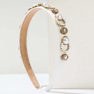 Macro detail of Baroque white satin headband with pearls and crystal in gold settings