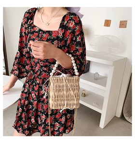 Detail of hand-woven straw bag with large faux pearl handle and floral dress pairing