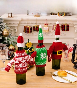 Detailed view of knitted Christmas wine bottle covers with reindeer and snowflake patterns
