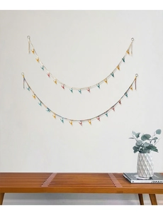 Detail of hand-woven cotton storage rope with colorful clips for hanging dolls and photos
