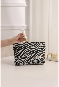 Macro detail of zebra print makeup bag showing textured fabric and spacious interior storage