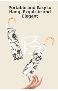 Detail of floral folding umbrella with curved gold handle and matching storage sleeve