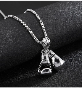 Macro view of silver stainless steel boxing glove pendant with durable box chain detail