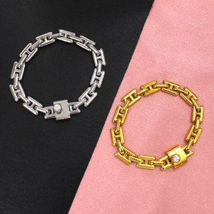 Close-up of gold and silver square link bracelets with a single inset crystal accent